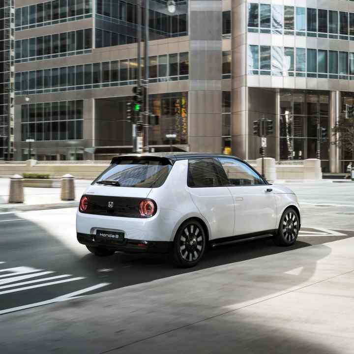 Honda e dans une rue avec des bâtiments en arrière-plan