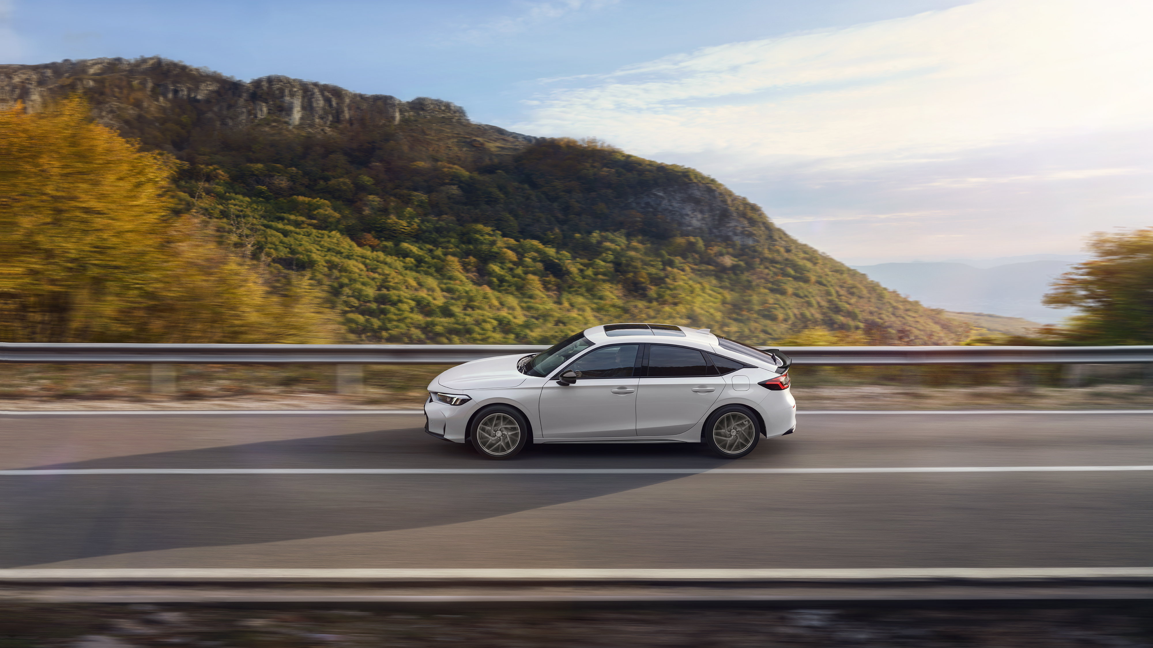 Honda Civic Hybrid en mouvement sur une autoroute, avec vue panoramique.