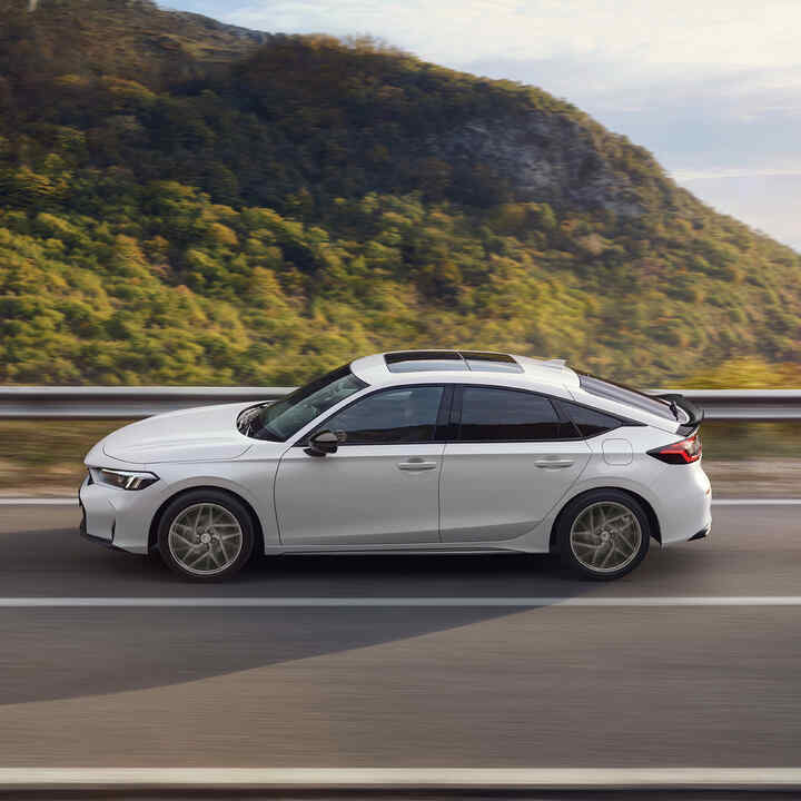 Honda Civic Hybrid en mouvement sur une autoroute, avec vue panoramique.