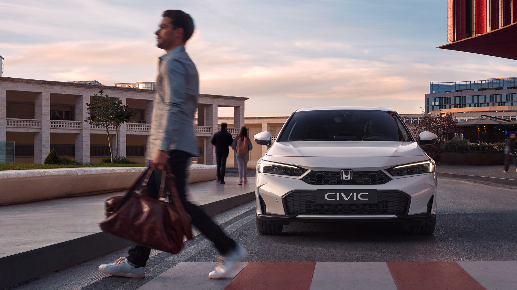 Honda Civic Hybrid s'approchant d'un homme devant un passage pour piétons.