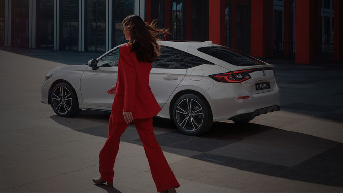 Une dame s'approche d'une Civic Hybrid