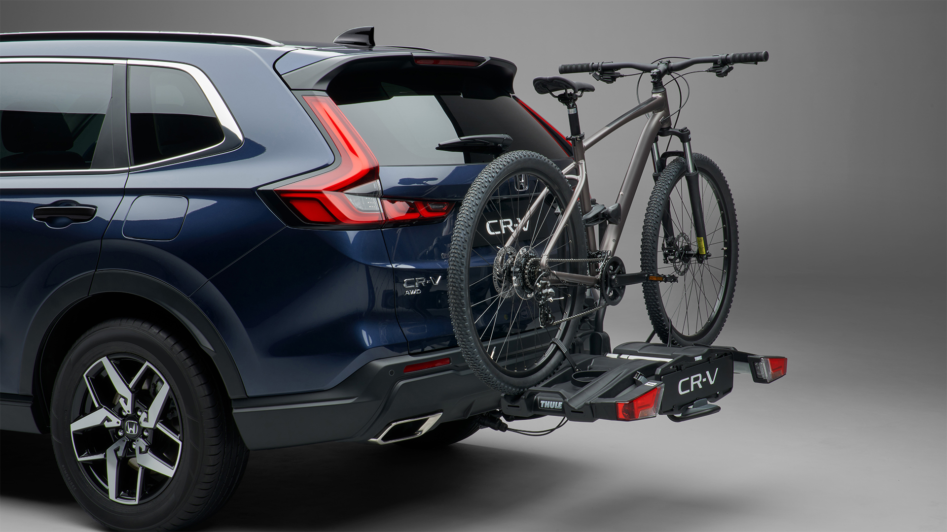 Vue de trois quarts arrière du Honda CR-V hybride avec porte-vélos.