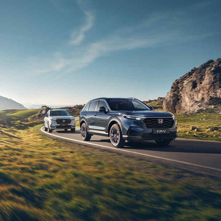 Vue de trois quarts face d'un CR-V hybride de Honda dans un environnement montagneux.