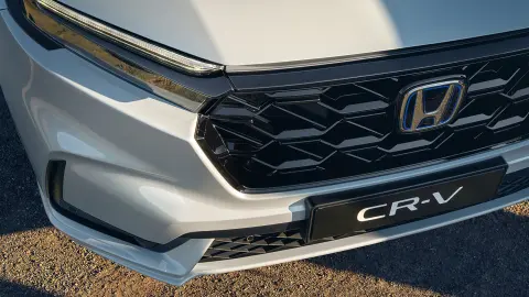 Gros plan sur la calandre grillagée avant du SUV hybride CR-V.