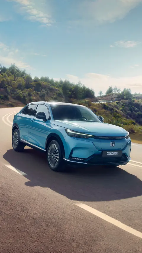 Honda e:Ny1 de face et trois quarts dans un endroit montagneux. 
