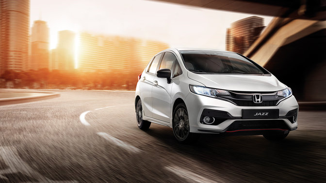 Vue de profil d'une Honda Jazz roulant &agrave; vive allure en ville.