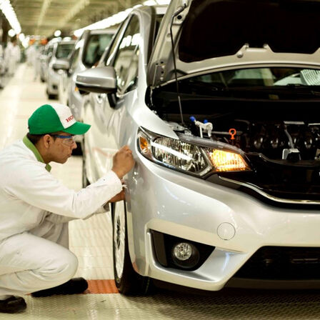 Technicien Honda travaillant sur une voiture à l'usine.