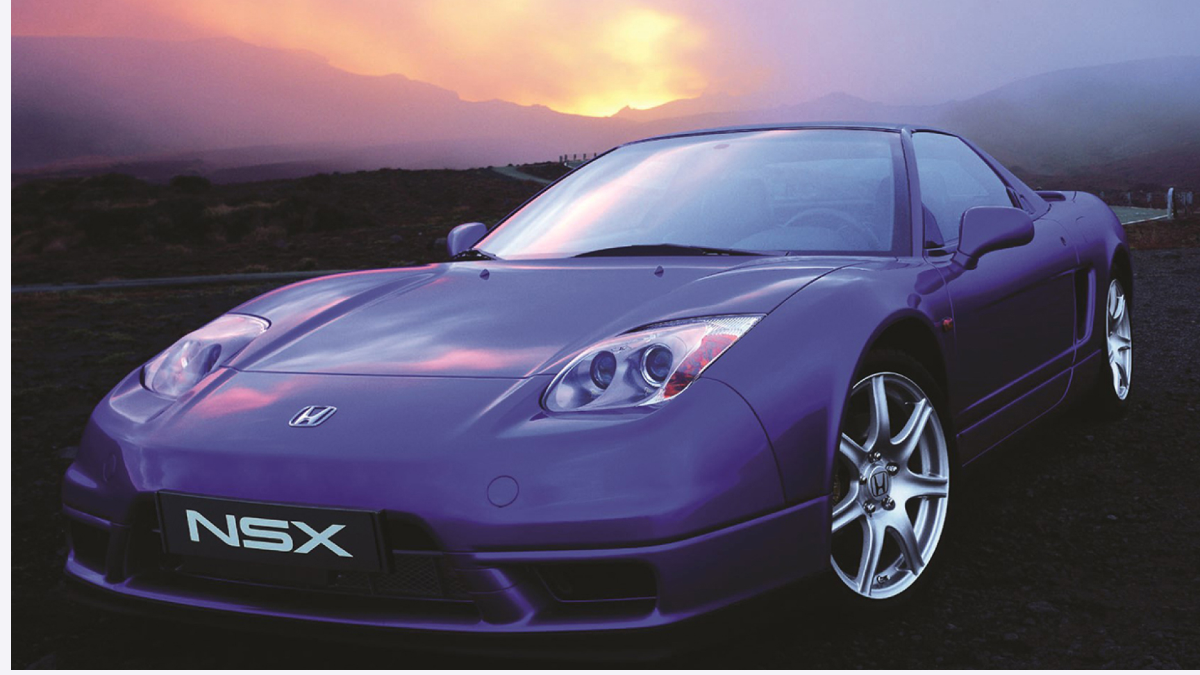 Vue de trois quarts face de la Honda NSX au coucher du soleil.