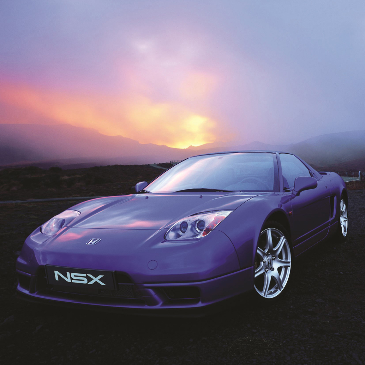 Vue de trois quarts face de la Honda NSX au coucher du soleil.