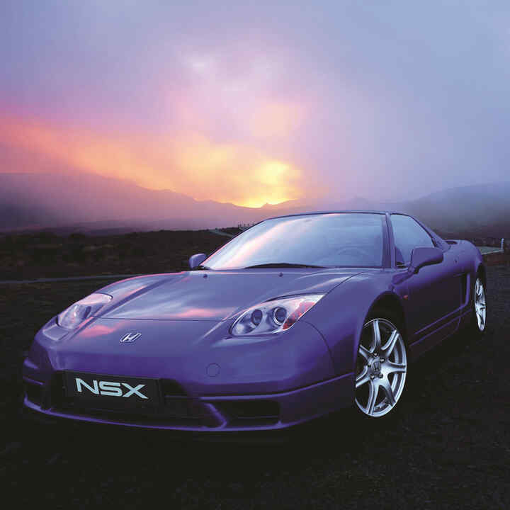 Vue de trois quarts face de la Honda NSX au coucher du soleil.