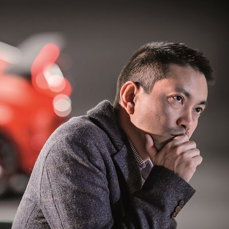 Vue de profil de la berline Honda Civic, avec un homme en pleine réflexion.