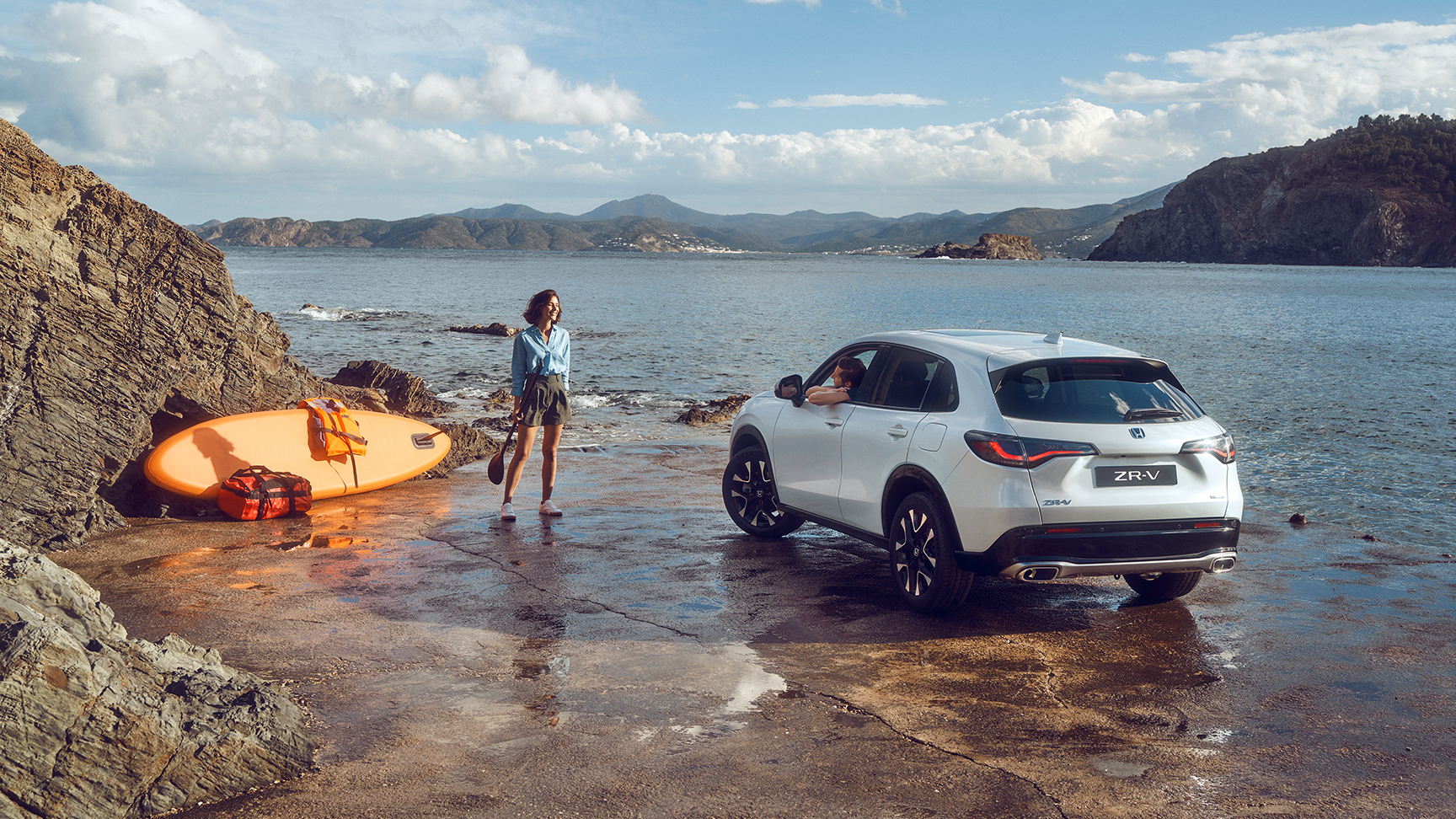 ZR-V blanc près d’une côte avec une femme et un canot