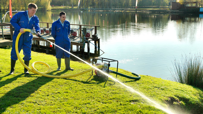 Pompe à eau haute pression utilisée par des modèles près d'un lac.