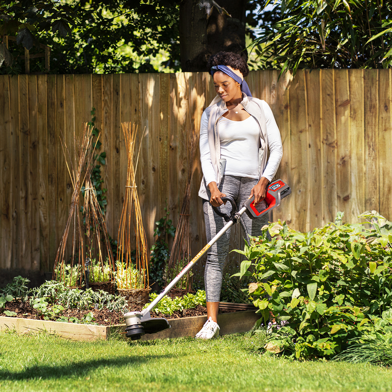 Femme utilisant une tondeuse sans fil