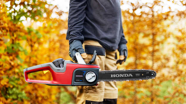 Une tronçonneuse à batterie HONDA dans une forêt.