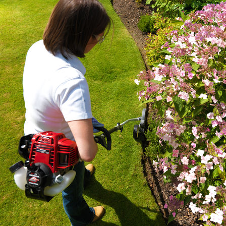 Honda Versatool™, plan sur un moteur 4 temps, utilisé par un démonstrateur, dans un jardin.
