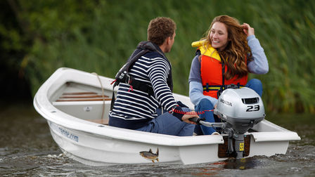 Une couple souriant, dans un canot sur un lac.