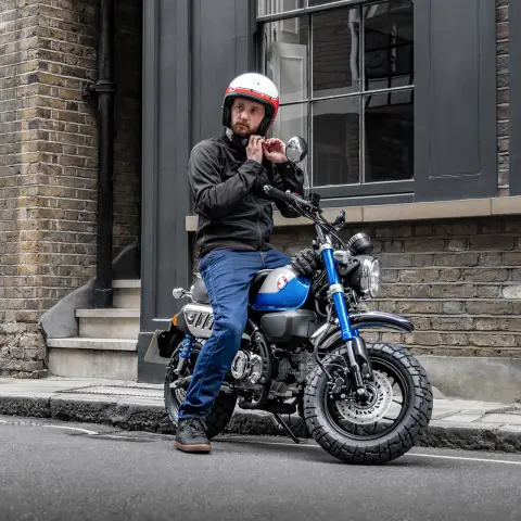 Honda Monkey 125 et son pilote, sur le côté de la route