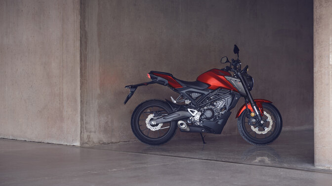 Honda Monkey sur béquille latérale sur une route avec pilote
