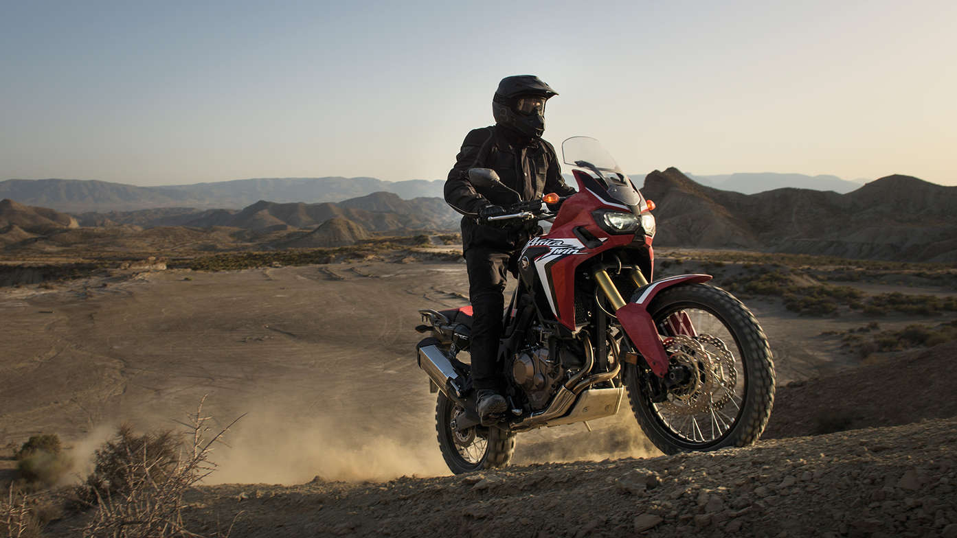 conducteur gravissant une colline sur une Africa Twin