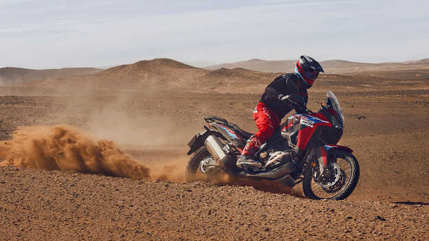 Mannequin conduisant une moto CRF1100L Africa Twin dans un environnement désertique.