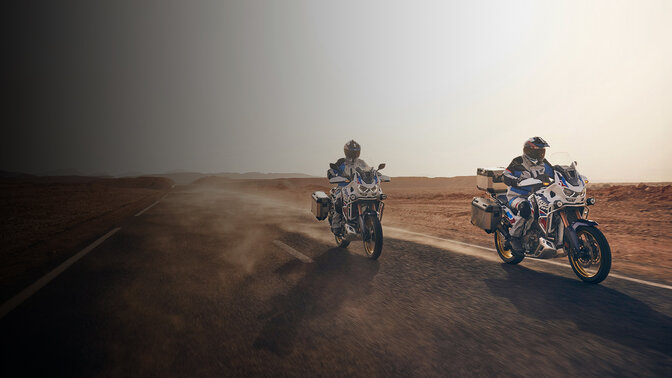 Motards vus de face de 3/4 sur CRF1100 Africa Twin Adventure Sports sur route dans le désert. 