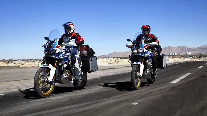 Deux pilotes conduisant les motos Honda Africa Twin Adventure Sports sur route.