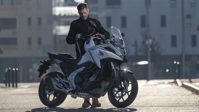 Honda NC750X, rouge, zoom sur le logo Honda, prise en studio