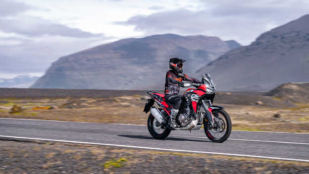 Vue de trois quarts avant de l’Africa Twin avec motard sur route