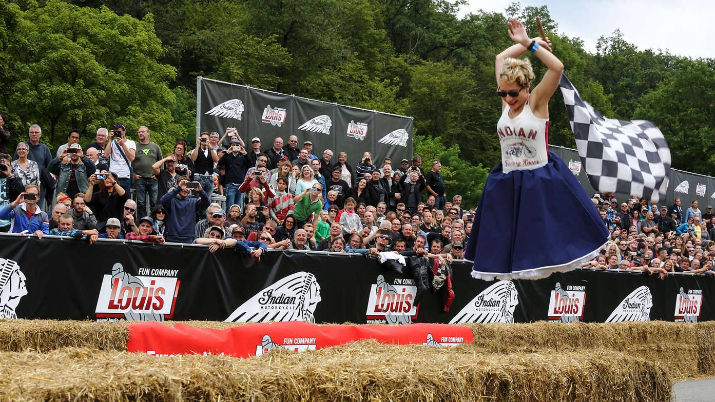 Une femme abaissant le drapeau à damiers.