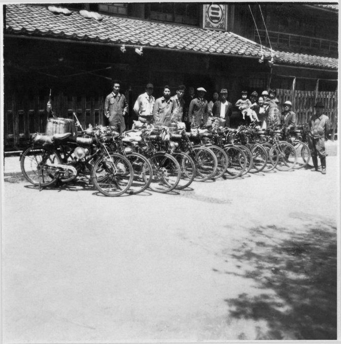 13 anciennes motos Honda alignées avec des gens derrière elles au Japon