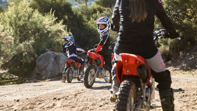 Honda CRF110F hors route avec de jeunes pilotes