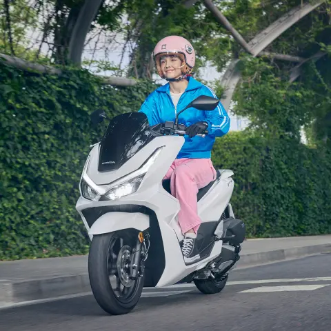 Mannequin sur une moto PCX125 dans un environnement urbain.