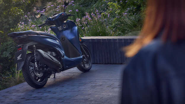 Honda SH350i vue de derrière dans un jardin. 