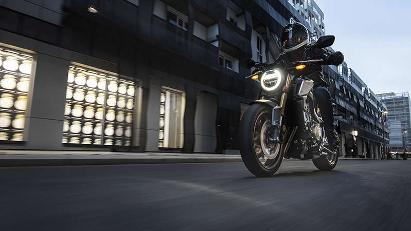 Vue de trois quarts gauche du Roadster Honda Permis A2 CB650R Neo Sports Café, piloté dans un paysage urbain