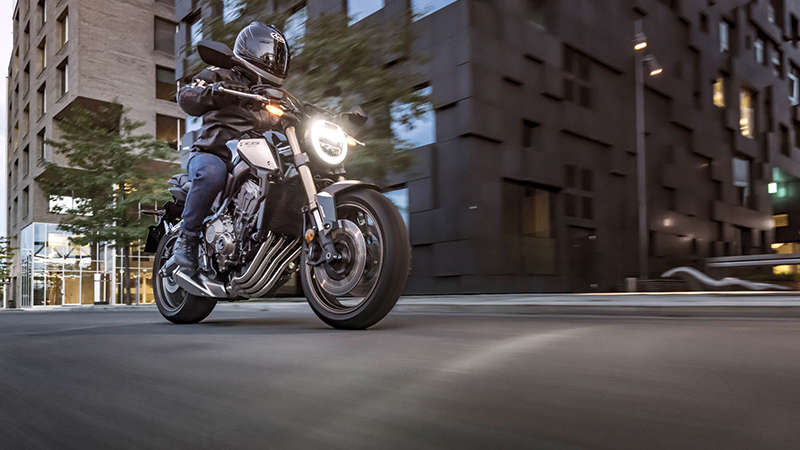 Vue de trois quarts droit du Roadster Honda Permis A2CB650R Neo Sports Café, pilotée dans un paysage urbain