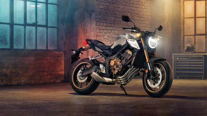 Vue de trois quarts avant droit du roadster CB650R Neo Sports Café, la nuit dans un paysage urbain