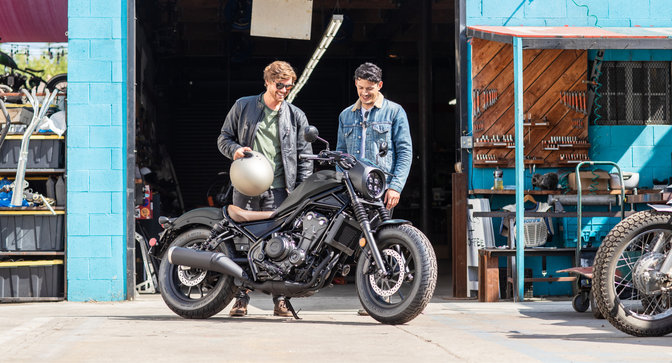 Moto custom permis A2 Honda CMX500 Rebel à l'arrêt devant un atelier.