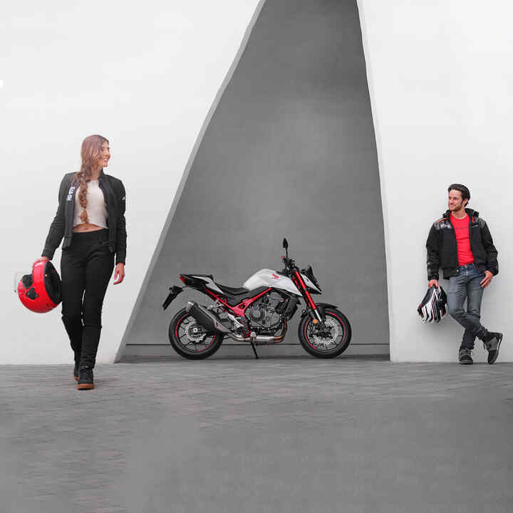 Un homme et une femme penchés à côté d'une moto roadster streefighter Honda CB750 Hornet - permis A2