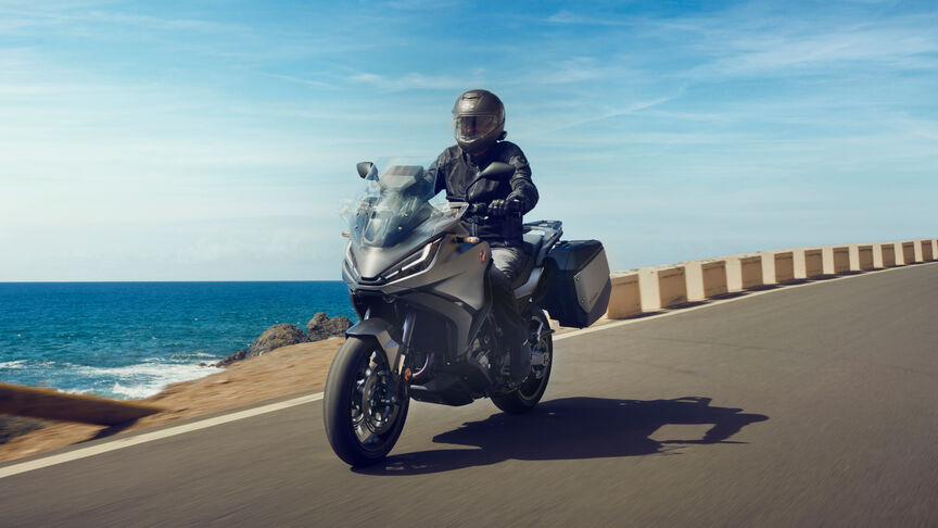 Moto routière Honda NT1100 mettant en avant la protection contre le vent et les dimensions compactes.