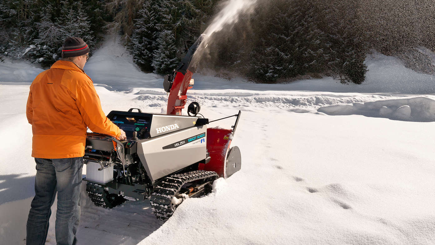 Fraise à neige Honda, utilisée par un démonstrateur, dans un lieu enneigé.